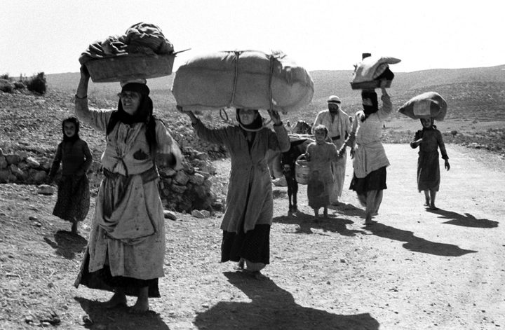 Mujeres cargan sus pertenencias sobre la cabeza durante el éxodo